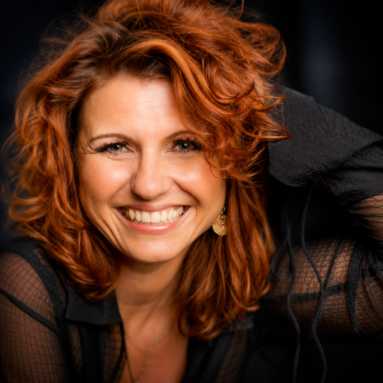 Mara Kaiser im Porträt, seitlich zur Kamera gewandt, in warmem Licht